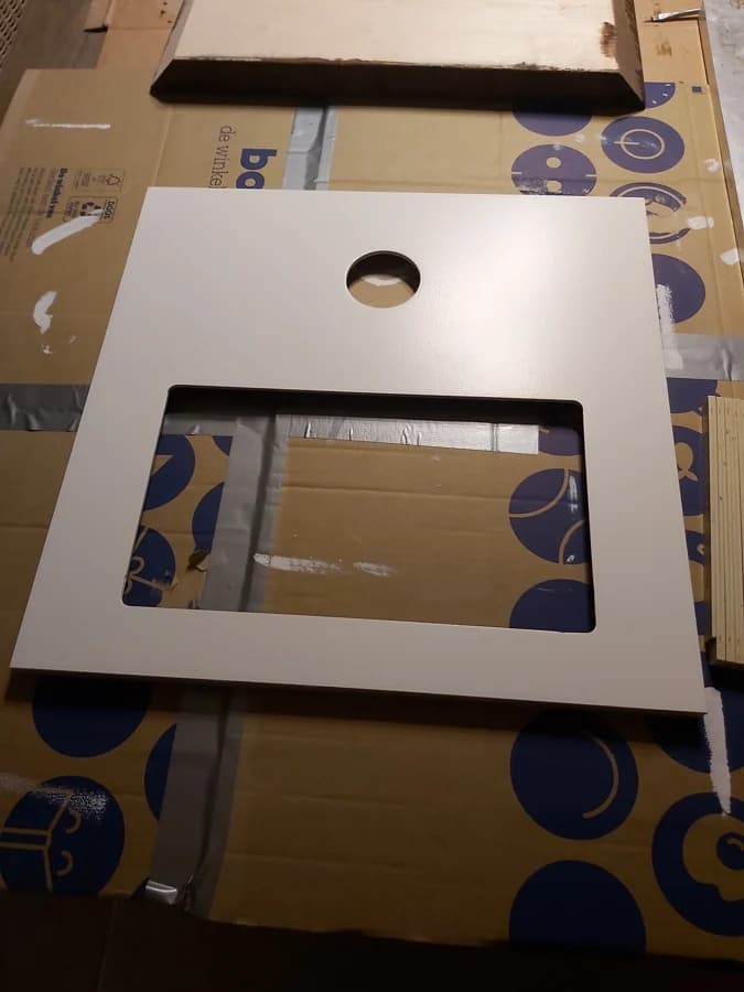 De uitgefreesde en gespoten frontplaat met gat voor de camera en uitsparing voor het scherm