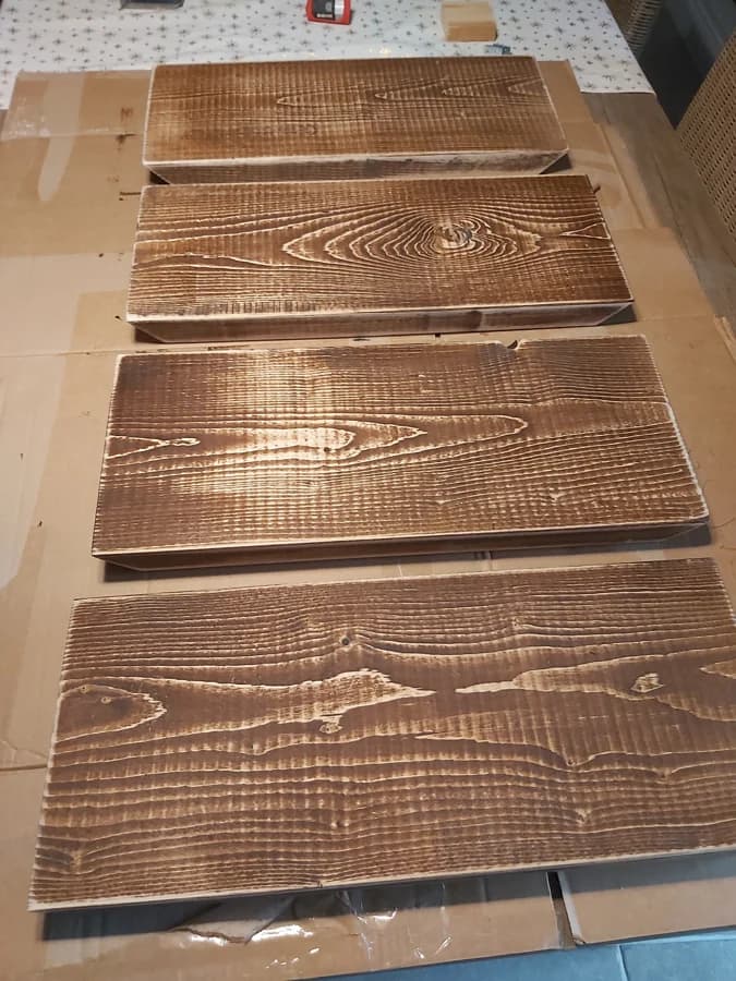 Vier geborstelde en gebeitste planken voor de eerste booth