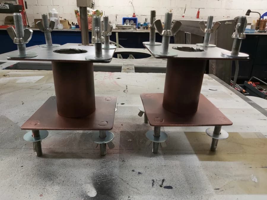 Twee metalen tussenstukken die de kast met het scherm verbinden met de onderbak