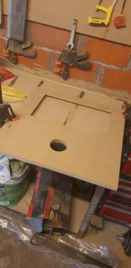 De frontplaat wordt uitgefreesd op de werkbank in de garage