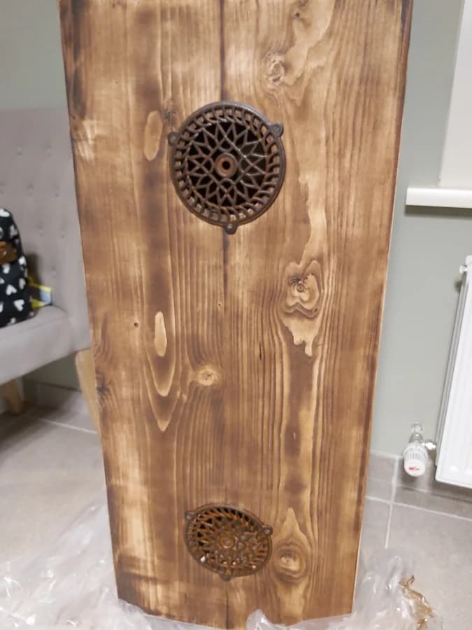 Houten zijpaneel met twee gietijzeren roosters