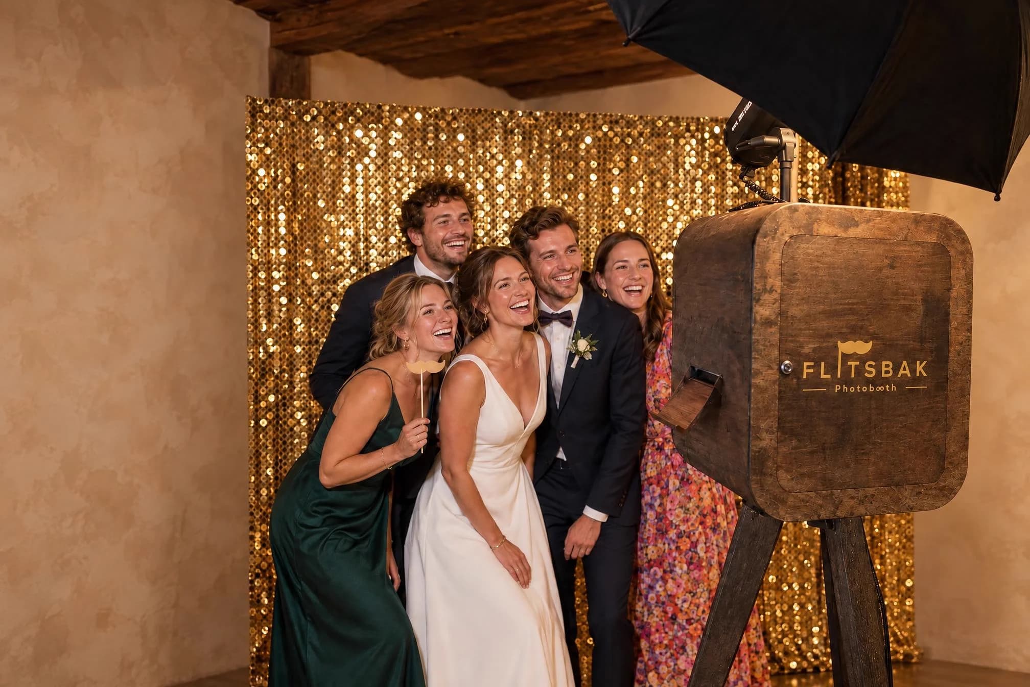 Bruidspaar en gasten poseren lachend voor de Flitsbak photobooth
