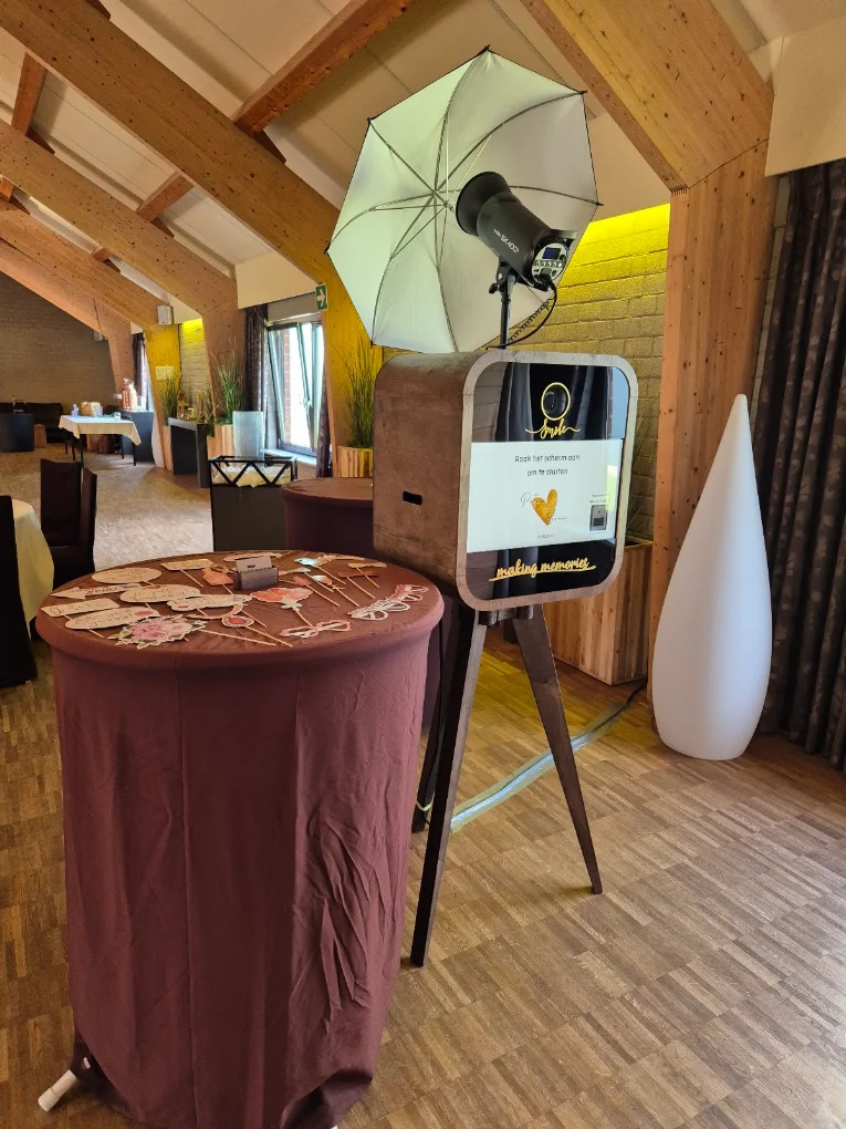 Flitsbak-photobooth met props-statafel in de feestzaal