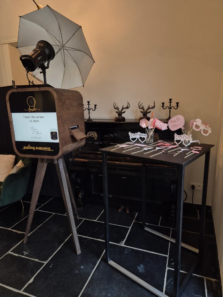 Flitsbak-photobooth met roze props en bloemen