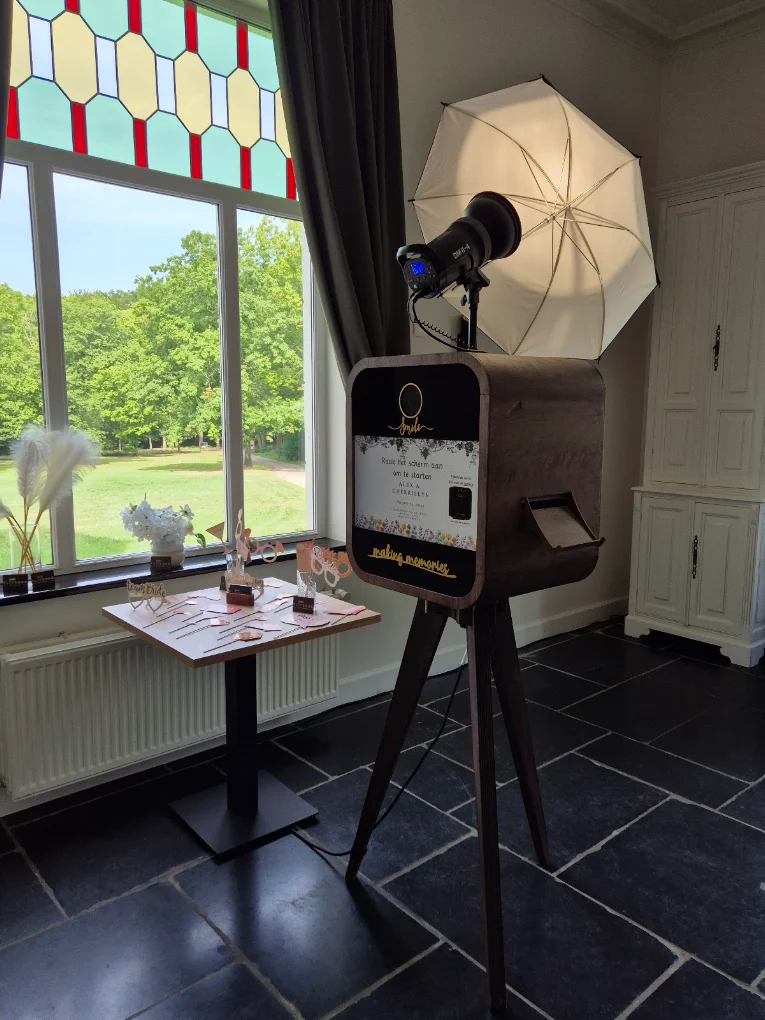 Flitsbak-photobooth bij een glas-in-loodraam met zicht op het park