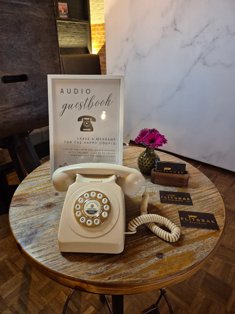 Trouwfoon op een rond houten tafeltje met audio gastenboek-kader