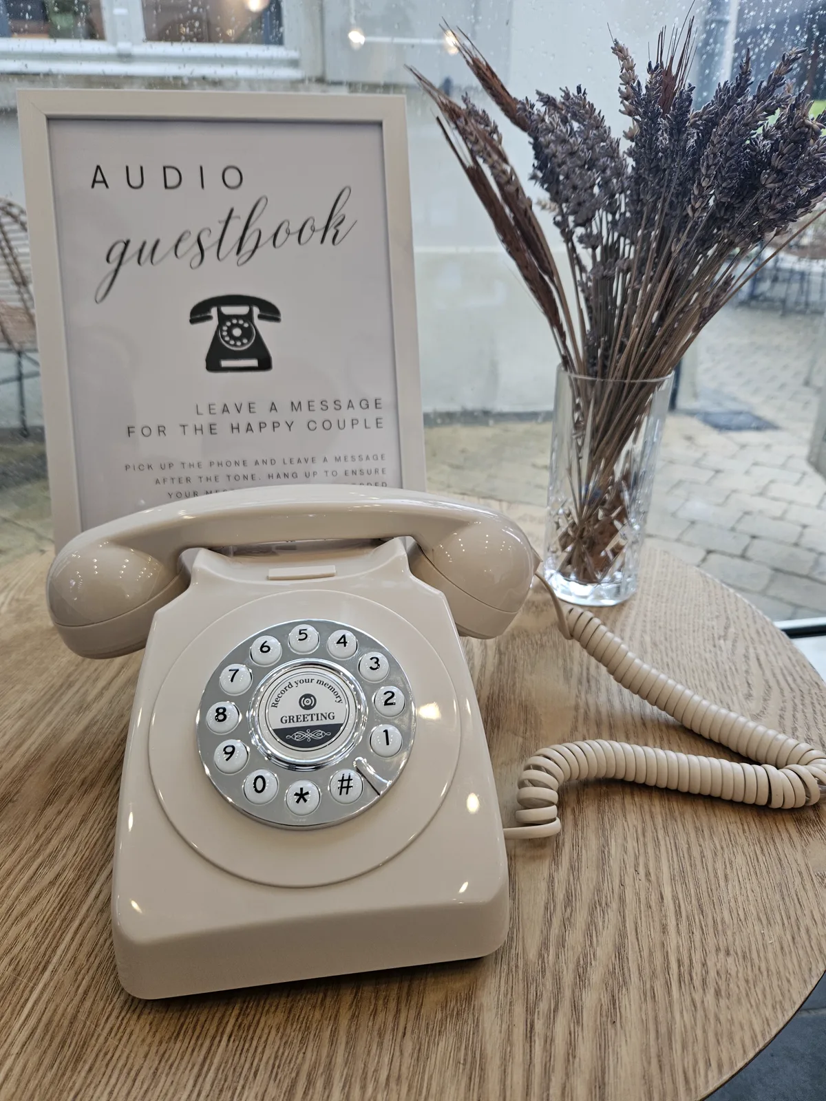 Beige trouwfoon met droogbloemen bij het raam